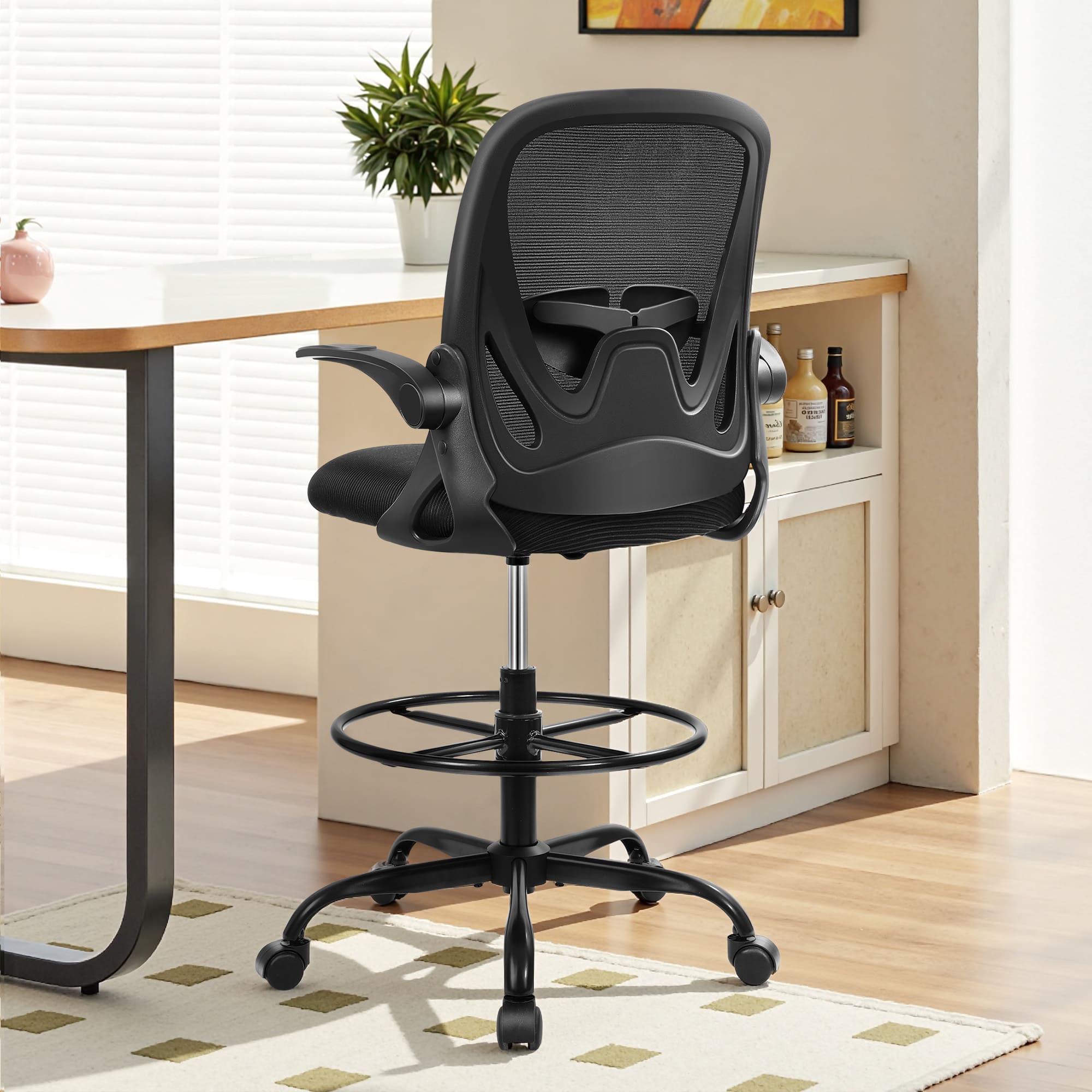 Black Primy 934-Z drafting chair with mesh back, flip-up arms, and foot ring.
